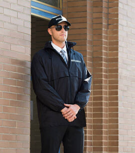 Young Male Security Guard Standing At The Entrance