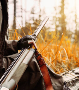 Woman hunter with a gun. Hunting in the woods.